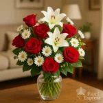 Bouquet romantico con rose rosse, gigli bianchi e margherite in vaso di vetro, consegna fiori a Milano.