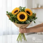 Bouquet con girasoli grandi e verde decorativo, confezionato in carta naturale con spago, realizzato da Fiori Express Milano.