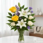 Bouquet con rose gialle, gigli bianchi e fiori viola in vaso di vetro, simbolo di gioia, eleganza e serenità, realizzato da Fiori Express Milano.