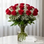 Bouquet elegante di rose rosse e gypsophila bianca in vaso di vetro trasparente, perfetto per esprimere amore e passione con stile raffinato.