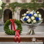 Corona di alloro fresca con fiocco rosso e bouquet bianco-blu per laurea in Informatica, consegna in giornata a domicilio a Milano centro