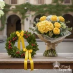 Corona d’alloro fresca con fiocco giallo in raso e bouquet rosa-pastello artigianale per laurea in Lettere e Filosofia, con consegna a domicilio in giornata a Milano centro